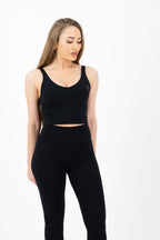 Woman wearing a black athletic outfit on a white background