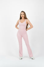 Woman wearing a pink jumpsuit on a white background